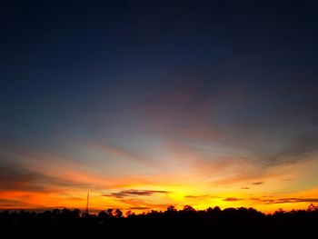 Silhouette landscape against dramatic sky during sunset