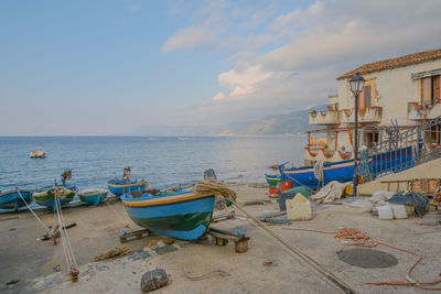 Boats moored on beach against sky