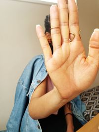 Woman gesturing stop sign at home