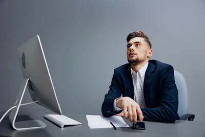 Portrait of businessman using laptop at office