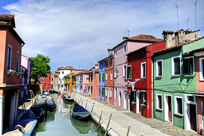 Boats moored in canal against sky