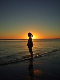 Full length of silhouette man standing on beach during sunset