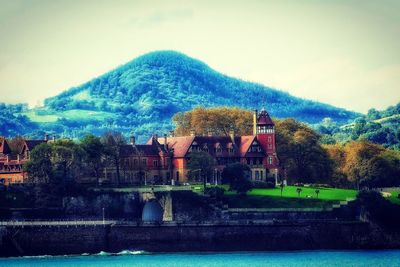 View of building by lake against sky