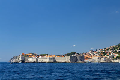 Town by sea against clear sky