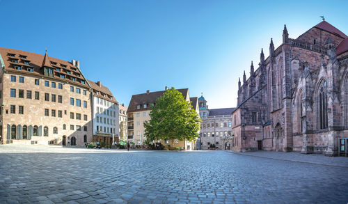 Buildings in city against clear blue sky