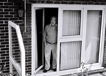 Portrait of man standing at window