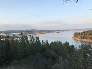 Scenic view of lake by trees against sky