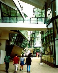 Rear view of people walking on modern building