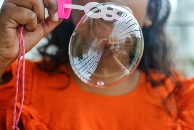 Midsection of girl blowing bubble