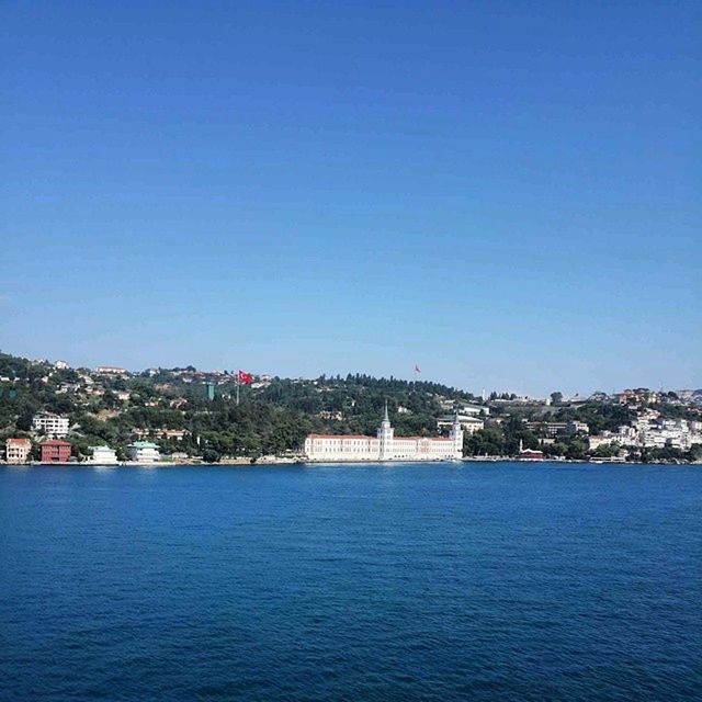 waterfront, water, blue, copy space, clear sky, building exterior, architecture, built structure, sea, tranquil scene, tranquility, scenics, rippled, river, city, nature, nautical vessel, beauty in nature, cityscape, outdoors