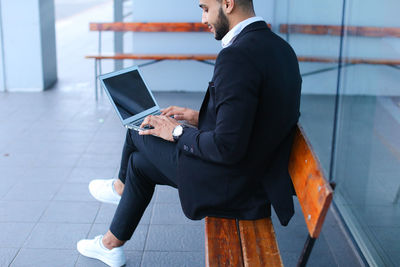 Low angle view of man working on mobile phone