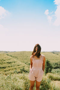 Woman standing on field against sky