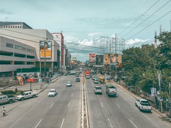 Traffic on road in city against sky