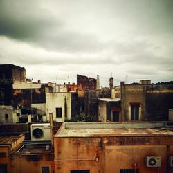 Buildings in city against cloudy sky