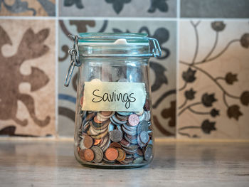 Small change savings in glass jar on kitchen tabletop