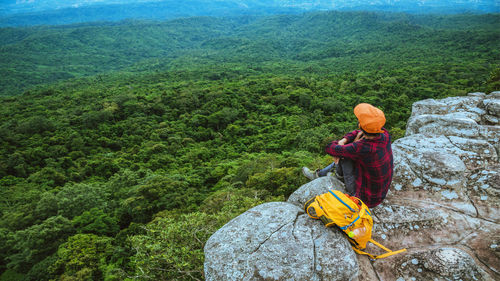 High angle view of man sitting on rock