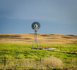 Windmill on field against sky