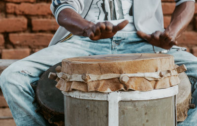 Midsection of man using drum