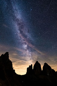 Low angle view of silhouette mountain against sky at night