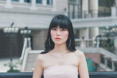 Portrait of young woman standing in city