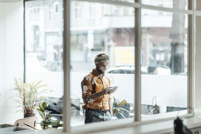 Woman looking through glass window