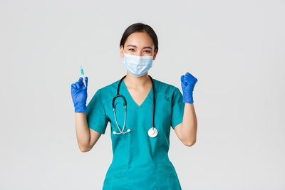 Portrait of teenage girl standing against white background