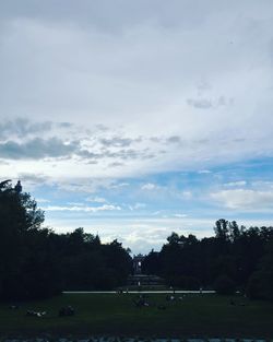 Scenic view of grassy field against cloudy sky