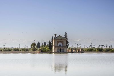 Building by lake against sky