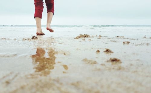 Low section of child standing on beach