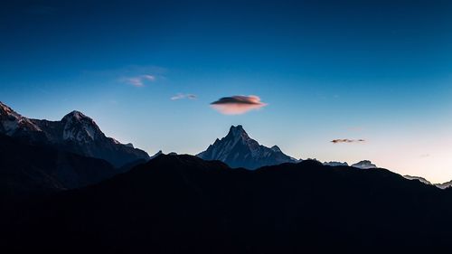 Silhouette mountains against blue sky