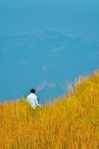 Full length of woman standing on grassy field against sky