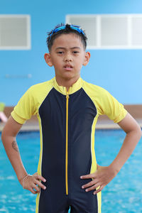 Portrait of boy standing at poolside