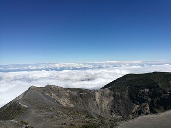 Scenic view of mountains against blue sky