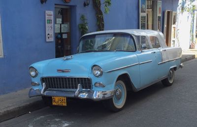 Vintage car parked on street against buildings