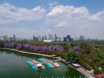 Scenic view of river by buildings against sky