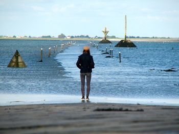 Rear view of woman standing on beach