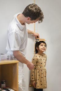 Doctor measuring girl in office