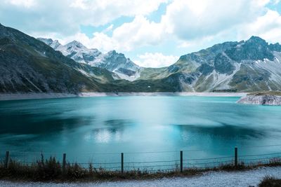 Scenic view of lake and snowcapped mountains against sky