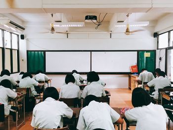 Rear view of people sitting in corridor