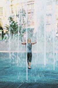 Rear view of child playing with water