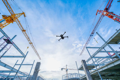 Low angle view of drone flying against sky