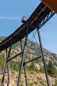 Low angle view of metallic structure on field against sky