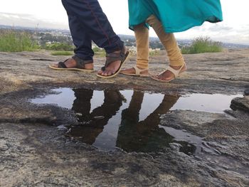 Low section of men walking on puddle