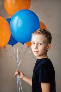 Portrait of boy holding balloons