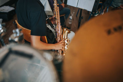 Midsection of man playing saxophone