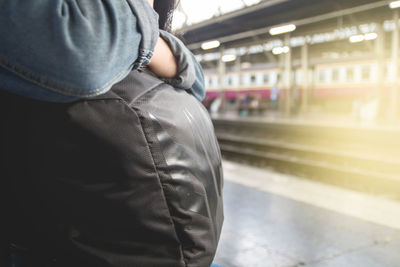 Midsection of woman at railroad station platform