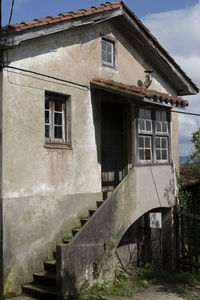 Low angle view of old abandoned house against sky