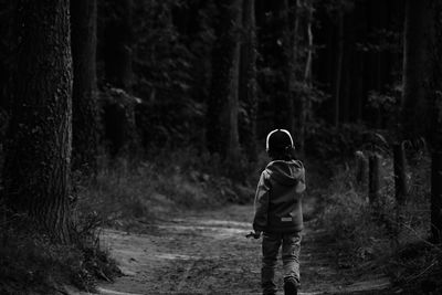 Rear view of kid walking in forest