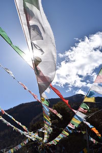 Low angle view of flags hanging against sky