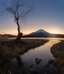 Scenic view of lake against sky at sunset